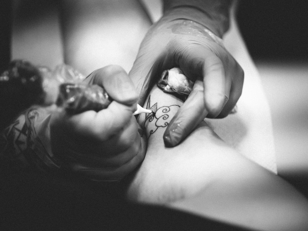 person-doing-flower-tattoo-on-leg-uvdrn-wi4p0